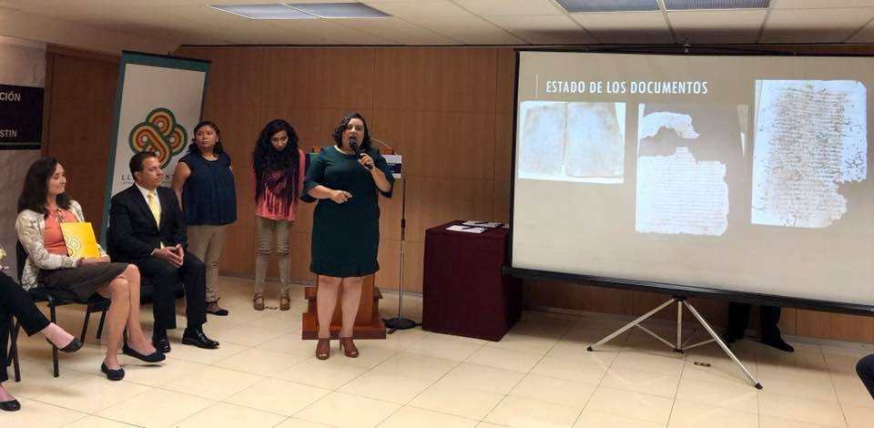 A member of the digitization team shows examples of the decayed state of some of the Cholula archives 