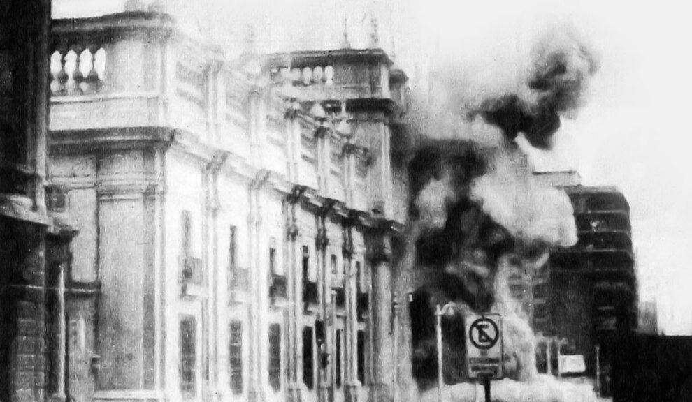 Black and white image shows a government building with billows of smoke coming out of it.
